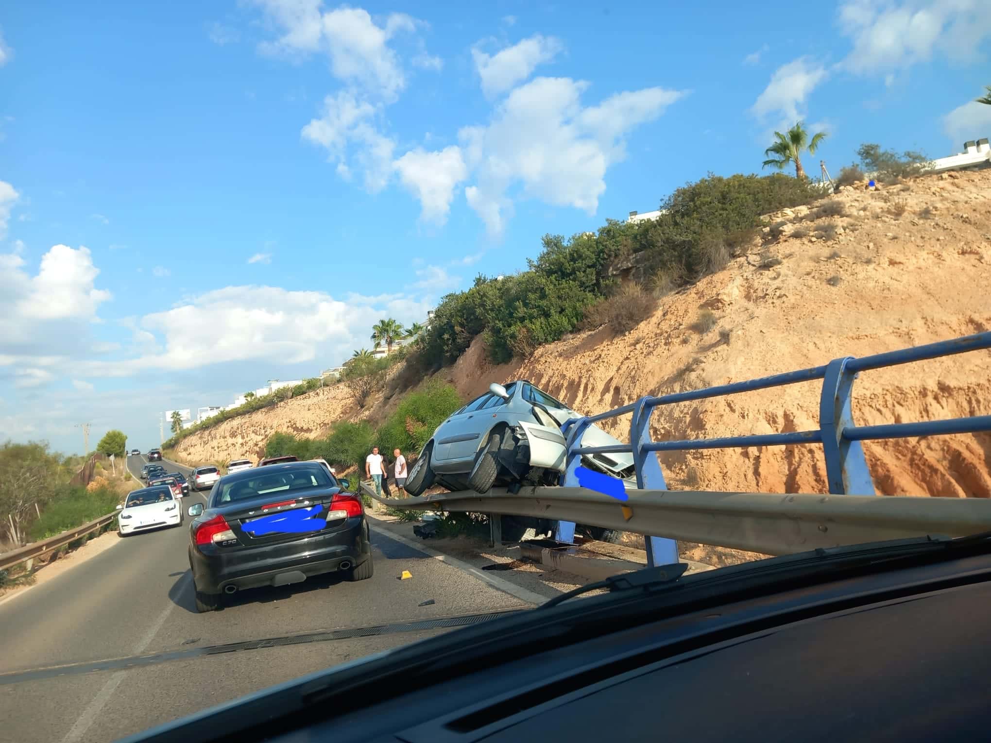 Un coche accidentado amenaza con caer sobre la AP-7 en Orihuela Costa